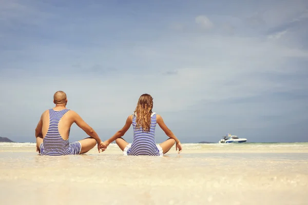 Casal na praia em maiôs de férias — Fotografia de Stock