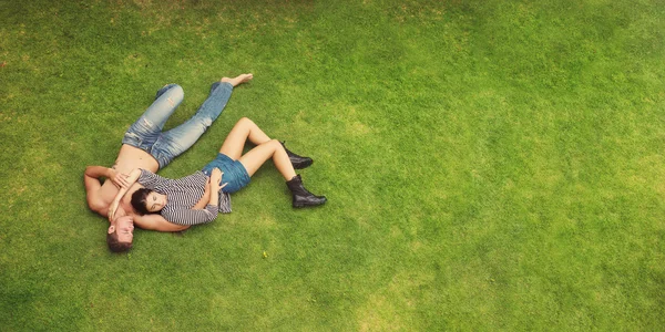 Coppia di moda sdraiato su erba verde — Foto Stock