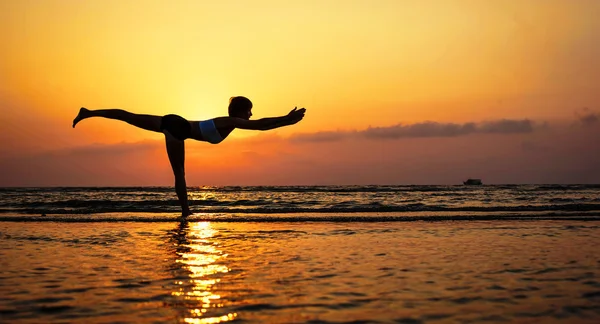 Gün batımında yoga yapan kadın. — Stok fotoğraf