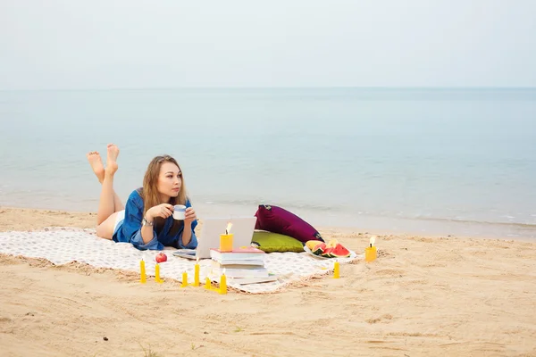 Femme avec ordinateur portable relaxant sur la plage — Photo