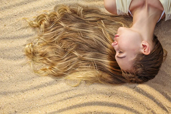 Woman hair in sand — Stock Photo, Image