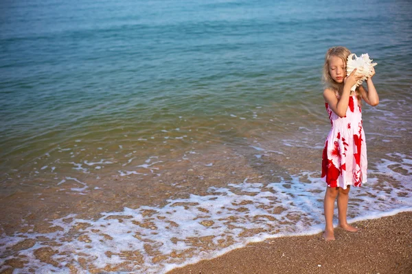 Chica en el mar escuchar el cockleshell —  Fotos de Stock