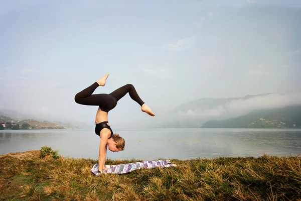 Mujer joven haciendo ejercicio de yoga en la mañana — Foto de Stock