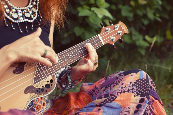 Krásná mladá žena na bederní nebo hippie v barevné oblečení hraje ukulele — Stock fotografie