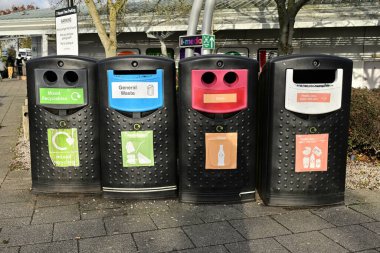 Geri dönüşümleri ve araba parkındaki atıkları ayıran renkli kutuların sırası
