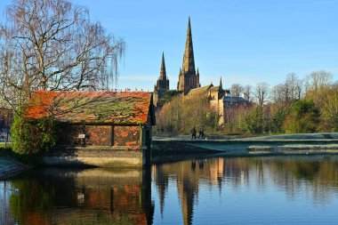 Tarihi İngiliz katedrali ve kır evi sakin kış gölü sabahına yansıdı.
