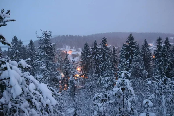 吹雪の中で遠くの村の光が光る — ストック写真