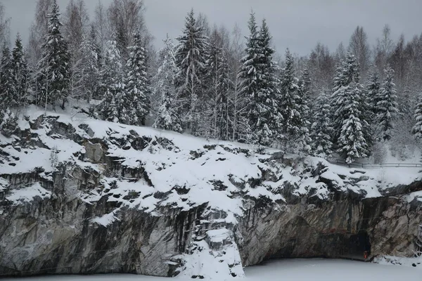 凍った湖の雪に覆われた岩の洞窟 — ストック写真