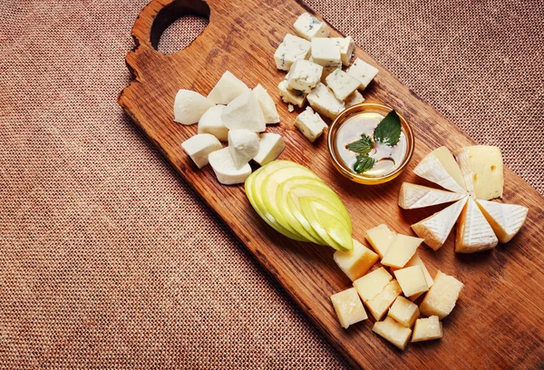 Cheese platter on rustic wooden board — Stock Photo, Image