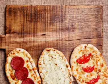 Tahta kesme tahtasında Türk pidesi. Mini pizzalar