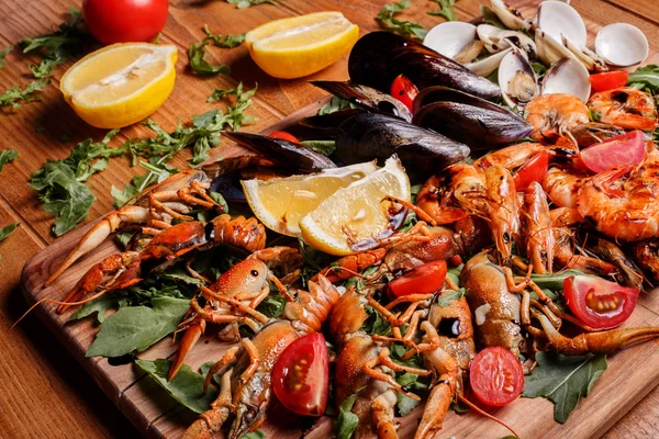 Fresh mussels, crayfish, shrimp on a wooden board. Seafood platt