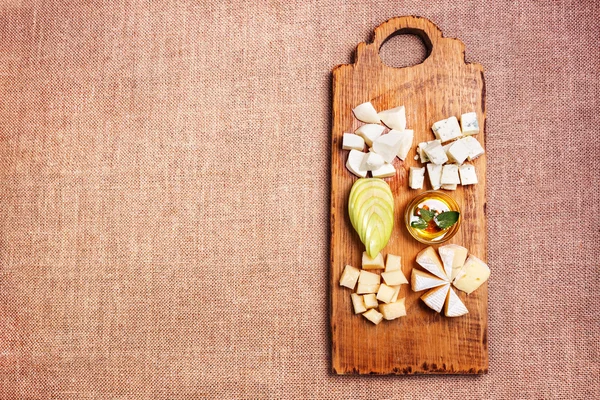 Cheese platter garnished on rustic wooden board — Stock Photo, Image