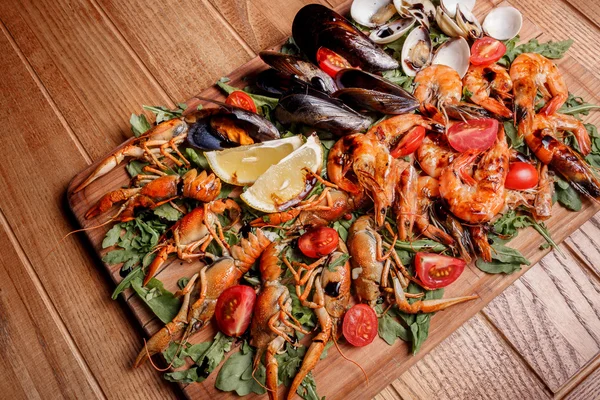 Fresh mussels, crayfish, shrimp decorated with arugula, tomatoes