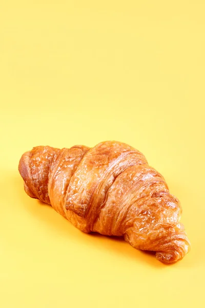 Croissant savoureux avec chocolat et confiture sur fond jaune. Pâtisseries et pain dans une boulangerie — Photo