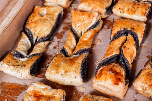 Söta bakverk, smördeg med vallmo fyllning på hyllan i bageri butiken. Bakverk och bröd i ett bageri — Stockfoto