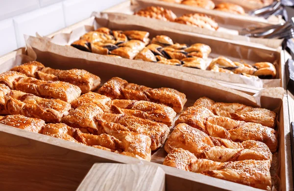 Verschiedene Blätterteigwaren, Croissants, Brötchen und Kuchen im Regal in der Bäckerei. Gebäck und Brot in einer Bäckerei — Stockfoto