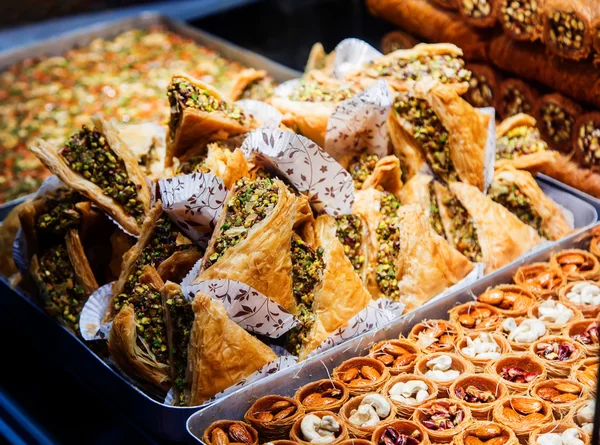 Eastern sweets in a wide range, baklava, Turkish delight with almond, cashew and pistachio nuts on plates — Stock Photo, Image