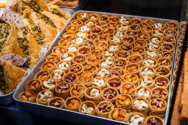 Bonbons orientaux dans une large gamme, baklava, délice turc aux amandes, noix de cajou et pistaches sur assiettes — Photo