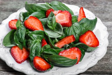 Çilek ve ahşap arka plan üzerinde ıspanak salatası