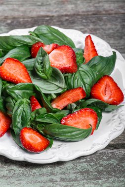 Çilek ve ahşap arka plan üzerinde ıspanak salatası