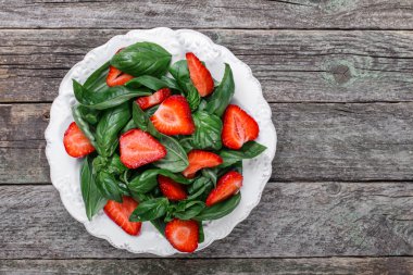 Çilek ve ahşap arka plan üzerinde ıspanak salatası. Üstten Görünüm