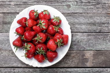 Tatlı olgun çilek plaka ahşap masa, seçici odak, üstten görünüm