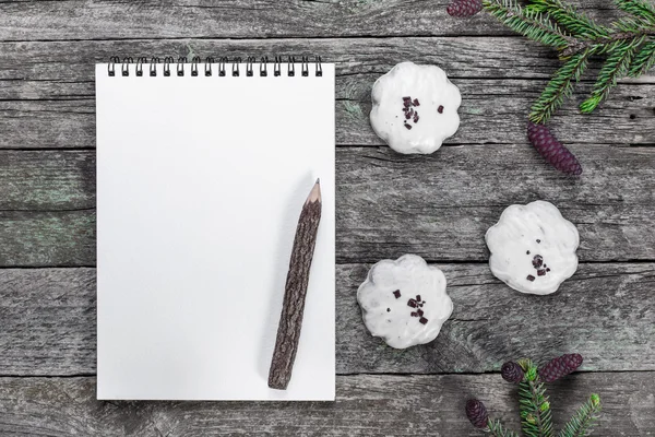 Bloco de notas em branco com lápis, biscoitos de Natal e ramos de abeto com cones na mesa de madeira rústica — Fotografia de Stock