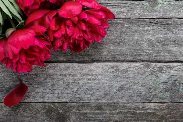 Prachtige roze pioenrozen bloemen op rustieke houten achtergrond. Selectieve aandacht, plaats voor tekst, bovenaanzicht — Stockfoto