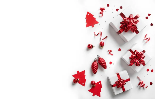 圣诞贺卡由圣诞礼品盒制成 上面有红色的蝴蝶结 装饰品 闪光和白色的背景 圣诞和新年的大旗上挂满了泡菜 灯火通明 闪闪发光 平躺在地上 俯瞰四周 — 图库照片