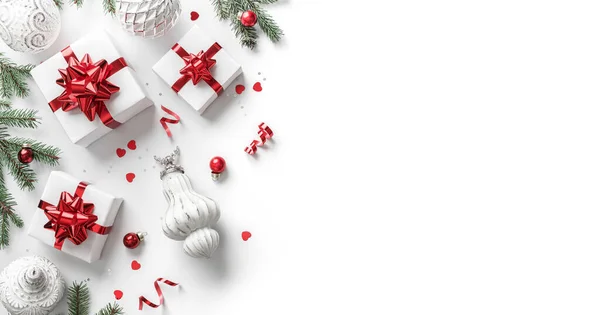 圣诞贺卡由圣诞礼品盒制成 附有红色蝴蝶结 银质装饰 冷杉枝条 闪光和白色背景的圆饼 圣诞和新年大旗 平躺在地上 俯瞰四周 — 图库照片