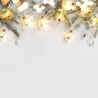 Beyaz arka planda gümüş süslemeli mutlu noel çelenkleri, köknar dalları, konfeti, bokeh, ışık, sim. Noel ve yeni yıl tebrik kartı, kış tatili. Düz yatış, üst görünüm