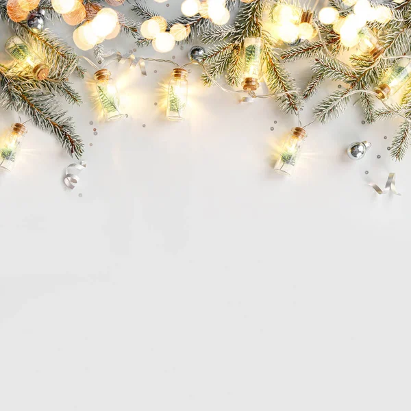 Рождественской Гирляндой Белом Фоне Серебряными Украшениями Еловыми Ветвями Конфетти Боке — стоковое фото
