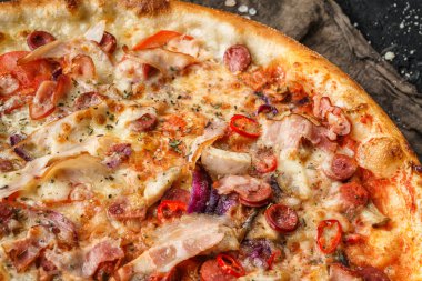 Prosciutto, sosis, peynirli parmesan, domates ve soğan halkalı pizza. Piknik şirketi için fast food, üst görünüm, seçici odaklanma.