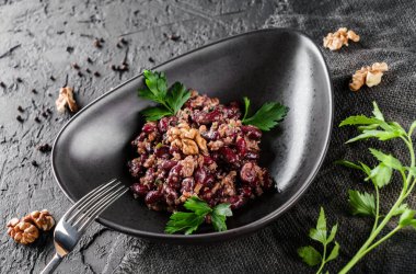 Sebzeli ve fındıklı siyah fasulye salatası koyu bir arkaplanda servis ediliyor. Sağlıklı yemek kavramı, temiz yemek, üst görüş.