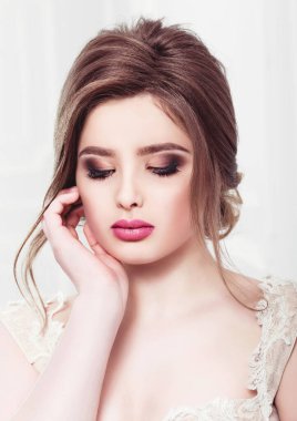 Lüks bir dairede gelinlik içinde güzel bir gelin. Moda makyajı ve saç stili. Genç ve güzel bir gelinin portresi. Düğün için. Stüdyo çekimi.