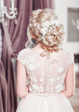 Lüks bir dairede gelinlik içinde güzel bir gelin. Moda makyajı ve saç stili. Genç ve güzel bir gelinin portresi. Düğün için. Stüdyo çekimi.