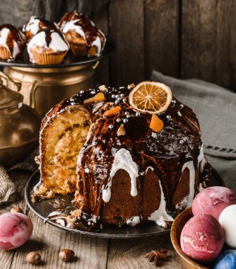 Çikolatalı Paskalya pastası ve taşralı ahşap masada fındık ve renkli paskalya yumurtaları. Mutlu Paskalyalar