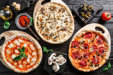Sosisli, jambonlu, jambonlu, jambonlu, jambonlu, salamlı, tavuklu, pepperonili, mantarlı, peynirli, yeşillikli, koyu ahşap arka planda sebzeli. Piknik şirketi için fast food öğle yemeği.