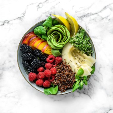 Kinoalı taze yaz salatası, şeftali, mikro yeşillikler, avokado, ahududu, böğürtlen, hindistan cevizi, hafif mermer kaplama kavun. Sağlıklı yemek, temiz yemek, Buda kasesi salatası, detoks, üst manzara.