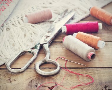 Makas, iplik ve iğneli makas, çizgili kumaş. Eski ahşap arka planda eski dikiş aletleri. Vintage Arkaplanı