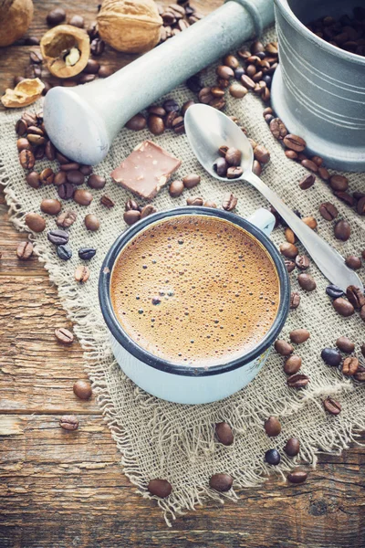 Кофе в металлической кружке на старом деревянном фоне с зерном — стоковое фото