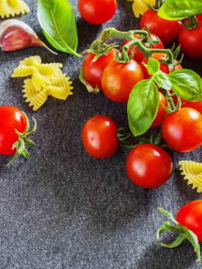 taze organik kiraz domates ve fesleğen sarımsak karanlık bir arka plan ile hamur.