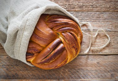 Taze somun ekmek bir çanta içinde eski ahşap zemin üzerine tarçın ile