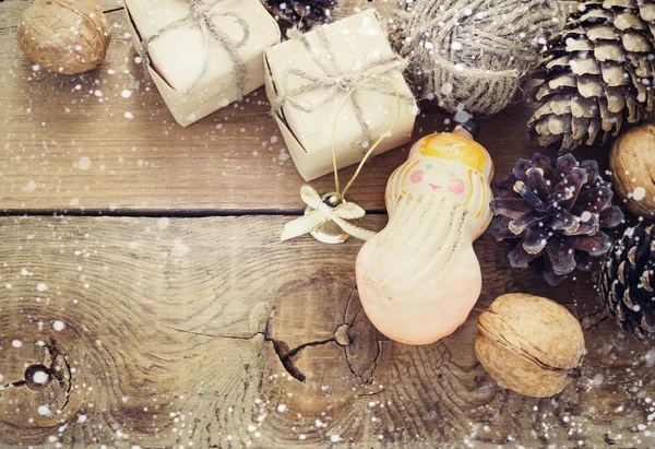 Brinquedos para a árvore de Natal e pinhas no fundo de madeira velha — Fotografia de Stock