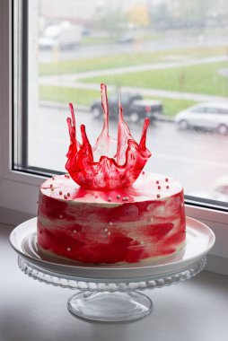 Pencere kenarında karamel süslemeli kırmızı parlak tatil pastası.