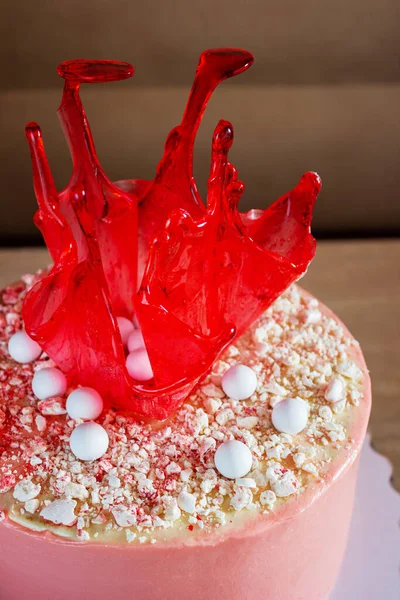 Pastel de cumpleaños rojo brillante con decoración de caramelo en la mesa Imagen De Stock