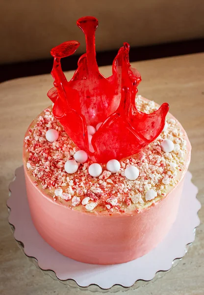 Pastel de cumpleaños rojo brillante con decoración de caramelo en la mesa Imágenes De Stock Sin Royalties Gratis