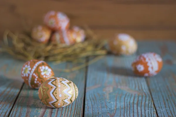 Uova di Pasqua nel nido su sfondo rustico in legno — Foto Stock
