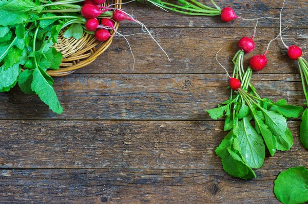 Fresh radishes on old wooden table — Stock Photo, Image