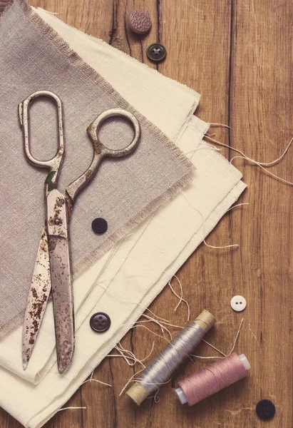 Kit de costura. Tesoura, bobinas com fio e agulhas no fundo de madeira velho — Fotografia de Stock